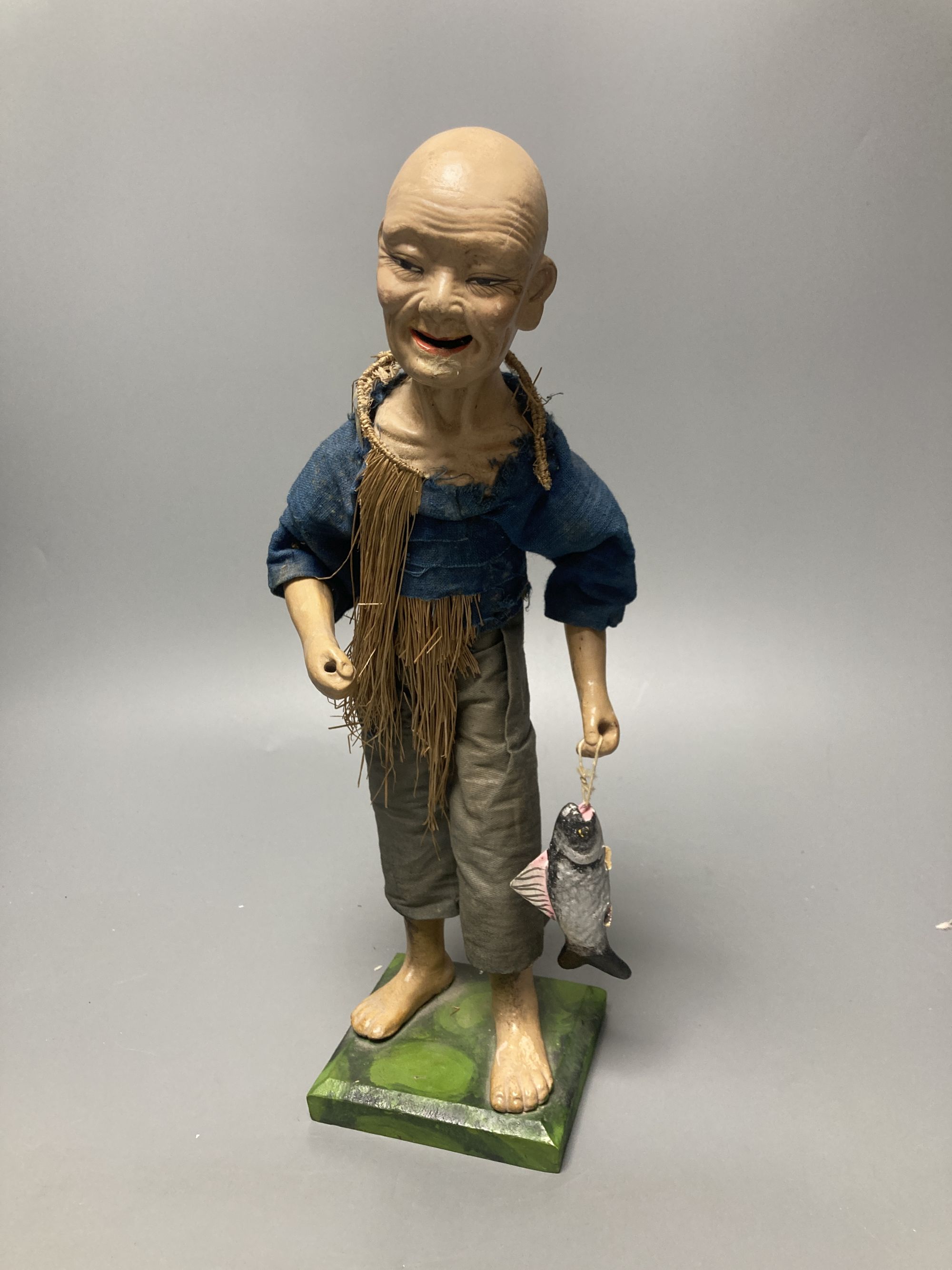 An early 20th century Chinese painted composition figure of a fisherman